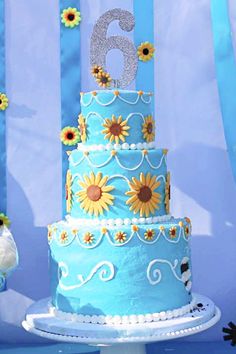 a blue and white cake with sunflowers on it