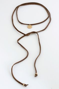 "The Leather Wrap Boho Choker is a fun and versatile necklace you can wear many different ways! Personalize the 1/2\" disc with initials, symbols, date, etc... *CHOOSE between an engraved, hammered or blank disc and BLACK or BROWN leather - premium 13mm (1/2\") 14k Gold Filled or Sterling Silver disc - GORGEOUS signature satin finish on the disc - 47\" genuine leather wrap with 14k gold filled or sterling silver bead at each end - hand made with care and love at our studio in San Diego, CA USA L Brown Resizable Waxed Cord Jewelry, Resizable Brown Waxed Cord Jewelry, Adjustable Brown Lariat Necklaces, Minimalist Jewelry With Adjustable Cord For Festival, Brown Lariat Jewelry For Gifts, Brown Lariat Jewelry With Adjustable Cord, Adjustable Everyday Choker, Brown Resizable Everyday Jewelry, Brown Adjustable Festival Jewelry