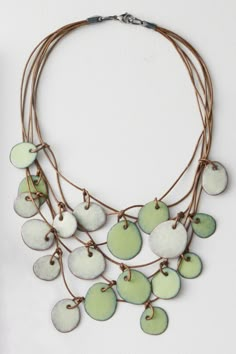 a necklace with green and white discs hanging from it