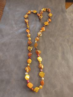 This necklace was made using dyed Abalone shell and freshwater pearl beads. Artisan Single Strand Orange Beaded Necklace, Orange Multi-strand Jewelry For Beach, Orange Multi-strand Jewelry For The Beach, Adjustable Orange Artisan Necklace, Artisan Orange Adjustable Necklace, Artisan Adjustable Orange Necklace, Adjustable Yellow Lariat Necklace, Adjustable Orange Multi-strand Necklaces, Brown Long Necklace With Colorful Beads For Gift