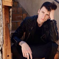 a man sitting on top of a stair case next to a hand rail with his head in his hands