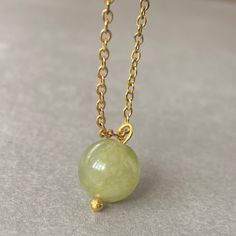 "UNIQUE GREEN JADE CRSYTAL CHAIN NECKLACE This necklace features a dainty, natural gemstone threaded on a 14k Gold Filled, Stainless Steel chain. Available in color options, this necklace is ideal for layering & makes the perfect gift! Please visit our store for other color options! Jade is believed to bring luck. Just like a four-leaf clover is considered a symbol of good fortune, jade is thought to have protective, lucky-charm energy.   ☆ Each of the stones we use to create necklaces were formed by nature over years. Each one is unique and beautiful just like nature itself.  We do not process or change our stones in any way, we accept their \"unique and raw\" beauties. We don't polish away \"flaws\" in the stones but rather leave them in their natural state.  Just like people, each stone Jade Gemstone Round Pendant Necklace, Jade Pendant Necklaces For Crafting, Elegant Jade Crystal Necklace For Gift, Elegant Jade Crystal Necklace As Gift, Gold Jade Necklaces With Round Beads, Gold Jade Necklace With Gemstone Beads, Gold Jade Crystal Necklace With Gemstone, Gold Jade Gemstone Crystal Necklace, Jade Necklaces With Round Beads For Gifts