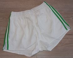 Original football shorts from 70's/80's era with cool retro design Designed in Western Germany 100% cotton Rare mint/unworn example of such a vintage shorts - please see photos Size on label: 5 - should fit well for men's S/M size Measurements: - waistband:      32cm - length:             30cm - leg opening:   29cm 7 Cotton Athletic Shorts With Three Stripes, Spring Cotton Shorts With Three Stripes, White Cotton Shorts With Three Stripes, Vintage White Cotton Shorts, Vintage Athletic Shorts For Summer, Vintage Summer Athletic Shorts, Green Retro Cotton Shorts, Green Cotton Retro Shorts, Retro Cotton Athletic Shorts