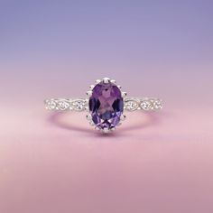 Introducing the exquisite "Juliet" Amethyst and White Topaz Ring – a timeless symbol of love and elegance. Crafted with passion and precision, this enchanting piece will captivate hearts and turn heads wherever it graces your hand. At the center of this ring lies a resplendent amethyst gemstone, deeply alluring with its regal purple hue. The amethyst, known for its association with tranquility and balance, embodies the spirit of royalty, making you feel like a true queen. Its mesmerizing violet Timeless Birthstone Ring For Promise, Timeless Promise Ring With Birthstone, Classic Amethyst Birthstone Promise Ring, Elegant Purple Birthstone Ring With Round Cut, Elegant Purple Round Cut Birthstone Ring, Elegant Amethyst Diamond Ring With Gemstone Accents, Elegant Amethyst Ring With Gemstone Accents For Promise, Elegant Amethyst Ring With Gemstone Accents For Anniversary, Elegant Purple Diamond Ring With Gemstone Accents