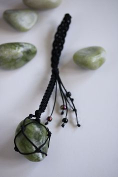 a green beaded necklace with black cord and beads hanging from it's end