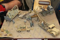 an assortment of toys including trucks and men in the desert, are displayed on a table