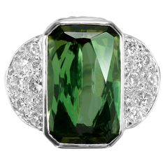 Vintage 1950's octagonal elongated green Tourmaline and diamond ring. Spectacular 7.46 Carat Green Octagonal Tourmaline Gubelin certified as natural Tourmaline. Accented with 16 Pavé set round full cut Diamonds in a platinum cocktail setting. The vibrant green tourmaline steals the spotlight in a mesmerizing octagonal cut, exuding elegance and sophistication. This ring is a true statement piece that will elevate any ensemble from simple to stunning. 1 octagonal bright green natural Tourmaline, a Vintage Cocktail Ring, Platinum Diamond Rings, Gold Cocktail Ring, Gold Cocktail, Diamond Cocktail Rings, Mineral Stone, Cushion Cut Diamonds, Princess Diamond, Vibrant Green