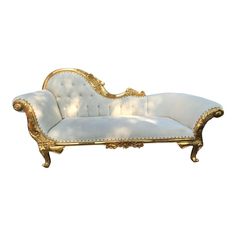 an ornate white and gold chaise lounge with golden trim on the back, in front of a white background