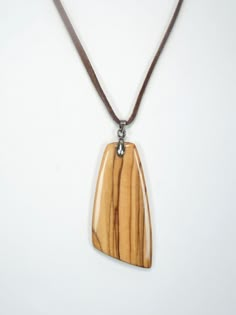 a wooden pendant is hanging on a brown cord