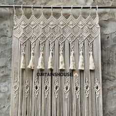 the macrame is made with white yarn and tassels hanging from it's sides