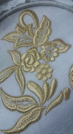 an embroidered pillow with gold flowers on it