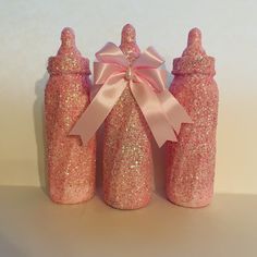 three pink glitter bottles with a bow on top