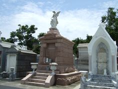 a cemetery with statues and trees in the background