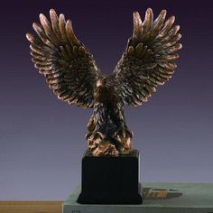 a bronze statue of an eagle sitting on top of a book