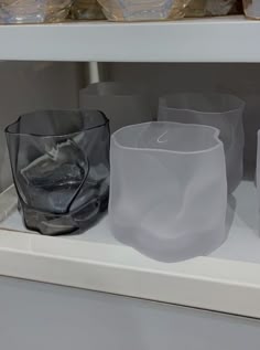 some glasses are sitting on a shelf next to each other