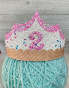 a ball of yarn with a knitted crown on top