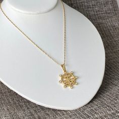 Our beautiful 18K gold-filled boat helm pendant necklace is perfect for boat lovers and cruisers!  The 25-mm-diameter boat helm pendant is adorned with shimmering rhinestones.  The gold chain is 1mm wide x 18".  Wear this stunning accessory whether you're on the water or on land!  Set your sail in style and allow the helm pendant to be a beacon of your adventurous spirit.  The helm also serves as a symbol of maritime spirit, navigation, or exploration.  Anti-tarnish and hypoallergenic.  Free of Casual Elegance, Resort Wear, Gold Chains, Gold Filled, 18k Gold, Jewelry Necklace Pendant, Jewelry Necklaces, Gift Card, Etsy Accessories