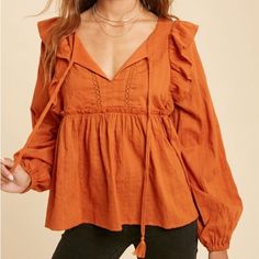 Boho Style Peasant Blouse With Ruffle Detail | Rust Split Neckline With Tassel Tie Long Sleeves With Elastic Cuffs Lace Ruffle Detail At Shoulders Gathered Ruffle Detail On Waist Chest Is Lined Flowy Top Fall Peasant V-neck Top, Chic Fall Peasant Top With Ruffles, Bohemian Ruffle Sleeve Tops For Fall, Bohemian Blouse With Ruffle Hem And Sleeves, Fall Peasant Top For Brunch, Fall Peasant Style Blouse For Brunch, Fall Peasant Top With Ruffles For Day Out, Fall Ruffled Peasant Top For Brunch, Fall Peasant Blouse For Brunch