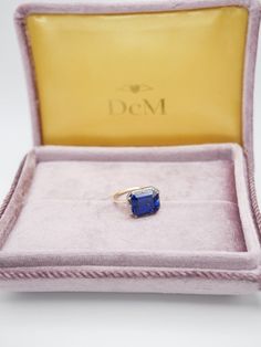 The Georgian-Victorian Emerald Cut Blue Sapphire & Blackened Gold East West Button Back Collet Ring—a timeless engagement piece inspired by the grace of the Georgian and Victorian periods. This ring photographed features a stunning 4 ct lab-grown sapphire in a Georgian cut-down collet setting and button back. It's not just an engagement ring; it's a versatile piece designed for stacking and layering with other styles. Lab Grown Gems: Our lab grown stones are not synthetic, or treated. These are Formal Sapphire Ring With Cushion Diamond Cut, Formal Sapphire Ring With Cushion Cut, Timeless Sapphire Wedding Ring, Classic Sapphire Baguette Cut Ring, Timeless Sapphire Ring As Gift, Timeless Sapphire Ring For Gift, Classic Sapphire Emerald-cut Ring, Timeless Sapphire Ring With Diamond Baguette Cut, Classic Emerald Cut Sapphire Birthstone Ring