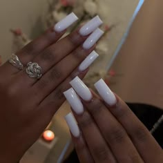 two hands with white nail polish holding each other