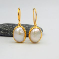 "White Fresh Water Baroque Pearl Drop Earrings. Sterling Silver 18k Gold Plated, 100% Handmade Unique Statement Earrings. PEARL: This enchanting June birthstone originates from oceans, lakes and rivers around the world. It is a timeless wardrobe staple, beloved by women of all ages. Pearls have long been associated with purity, humility and innocence. So it may be said that the June birthstone meaning is \"sweet simplicity.\" As such, pearls were traditionally given as a wedding gift. THE EARRIN Anniversary Bridal Earrings With Pearl Drop In Yellow Gold, Anniversary Bridal Earrings In Yellow Gold With Pearl Drop, Graceful Yellow Gold Wedding Earrings, Anniversary Yellow Gold Bridal Earrings With Pearl Drop, Graceful Yellow Gold Earrings For Gift, Elegant Handmade Oval Pearl Earrings, Pear-shaped Yellow Gold Bridal Earrings For Anniversary, Yellow Gold Pear-shaped Bridal Earrings For Anniversary, Graceful Yellow Gold Pearl Earrings Gift