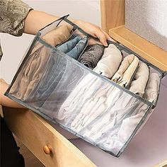 a woman is holding an open drawer with several pairs of shoes in it