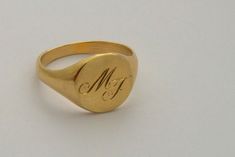 "A classic hand engraved signet ring for men or women, custom engraved solid gold ring in 14k gold. A beautiful 14K yellow gold signet ring. This ring can be customized: It can be hand engraved to up to 3 letters. The engraving can be made with a font of your choosing - you can even write it in your own handwriting - nothing is more personalized than this <3 This minimalist ring is light and comfortable to wear and will be great for everyday use, as for a special occasion. A great and unique Signate Rings, Signet Ring Women, Signet Ring For Men, Engraved Signet Ring, Silver Gold Ring, Bike Jewelry, Pinky Signet Ring, Unique Gold Rings, Custom Signet Ring