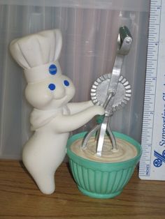 there is a toy chef holding scissors in a bowl