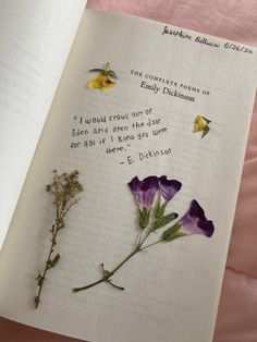 an open book with some flowers on it