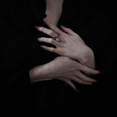 two hands are holding each other in the dark, with one hand on the other's chest