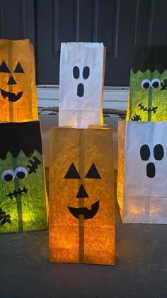 three paper bags with faces on them are sitting in front of a door decorated for halloween