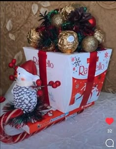 a christmas present wrapped in red and white paper with a penguin figurine on top