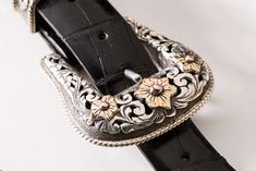 Only master silversmiths like those at Comstock Heritage could create such delicate detail with metals on this exquisite buckle set. Using a floral motif throughout each of the four pieces, they have used a variety of materials and techniques. Each piece is hand-engraved and made from silver filigree that is then overlain with fourteen-carat gold. The two keepers have one gold flower, the tip two, the buckle three. Underneath them all is finely engraved silver scrollwork. To finish things off, t Silver Engraving, Gold Piece, Gold Flower, Delicate Details, Silver Filigree, Something Beautiful, Gold Flowers, Hand Engraving, The Four