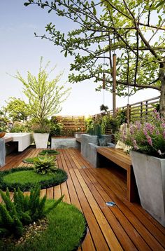 a wooden deck with benches and plants on it