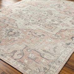 an antique rug on the floor with wood floors