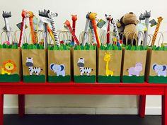 a red table topped with brown bags filled with animals and giraffe's