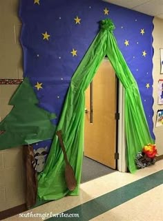 a classroom decorated for christmas with a green tent on the wall and brooms in front of it