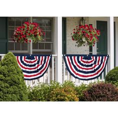 two potted plants with red flowers on them in front of an american flag banner