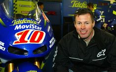 a man sitting next to a motorcycle helmet