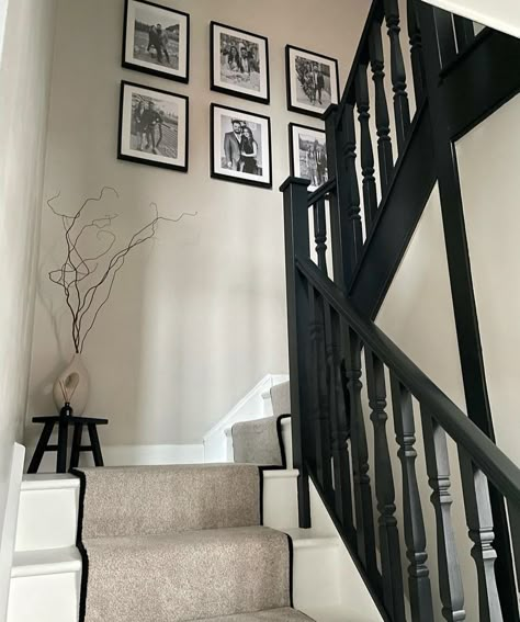 Corner Of Hallway Ideas, Cream And Black Staircase, Black Banister Hallway, Hallway Ideas Black Bannister, Beige And Black Stairs, Black And White Hall Stairs And Landing, Egyptian Cotton And Black Hallway, Neutral And Black Hallway, Top Of Stairs Corner Decor