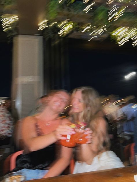 Two girls go out to a roof top bar in Columbus ohio. The photo is blurry as the girls cheers their drinks. There are lights above them. Roof Top Bar Aesthetic, College Going Out Aesthetic, Bar Friends Aesthetic, Going Out Vibes, College Night Out, Roof Top Bar, Nights Out, Night Out Pictures, Going Out With Friends