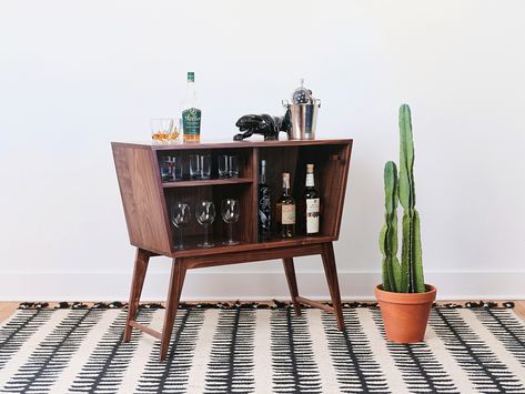 This mid-century modern liquor cabinet allows you to display and store your collection in one stylish place. It is designed to hold liquor and wine on one side and wine glasses and cocktail glasses on the other. It is made from 3/4" all SOLID WOOD, no veneers or particle board. The front features two sliding glass doors with custom matching handles. This piece is built using hidden floating tenon joinery and will last long enough to achieve heirloom status. Mid Century Modern Liquor Cabinet, Modern Liquor Cabinet, Atomic Rose, Black Bar Cabinet, Alcohol Cabinet, Mid Century Bar Cabinet, Modern Bar Cabinet, Painted Furniture For Sale, Modern Bar Cart