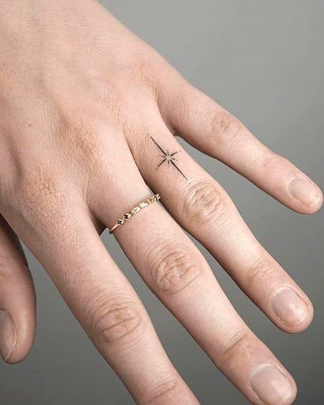 50 Dreamy Star Tattoos and Their Meanings (2022) - The Trend Spotter Star Ring Tattoo, North Star Tattoo Finger, Star On Finger Tattoo, North Star Finger Tattoo, Delicate Star Tattoo, North Star Tattoo Meaning, Sparkle Finger Tattoo, Star Tattoos Meaning, Light Tattoos