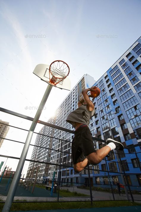 Basketball Player Jumping Action Shot by seventyfourimages. Low angle action shot of African basketball player jumping while shooting slam dunk in outdoor court, copy space #AD #angle, #seventyfourimages, #action, #African Frog Perspective, Basketball Photo Shoot, Motion Poses, Protagonist Aesthetic, Basketball Shot, Basketball Pictures Poses, Sports Poses, Swan Wings, Basketball Ideas