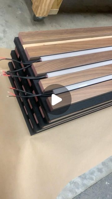 Cory Wasmus on Instagram: "Explore our latest project: walnut slats on black acoustical panels with integrated linear LED lighting. Join us behind the scenes as we prepare this custom wood ceiling and wall project to ship from our workshop in Ohio to destinations across the country! #acousticalpanels #woodwalls #woodceiling #architecturallightingdesign" Wood Panel With Light, Led Slat Wall, Wood Slats Ceiling, Wooden Slat Wall Living Room, Ceiling Panels Ideas, Wood Panelling Walls, Acoustic Panels Wall Design, Slat Wall Ideas, Wood Panel Lighting