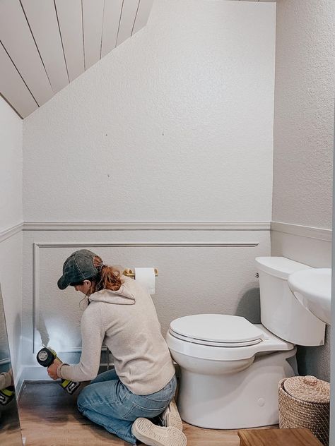 woman installing picture frame molding in a powder room Picture Frame Molding Bathroom Vanity, Half Bath Molding, Box Molding Small Bathroom, Picture Frame Molding In Bathroom, Bathroom Picture Molding, Powder Room Trim, Picture Frame Molding Bathroom, Chair Molding, Bathroom Box