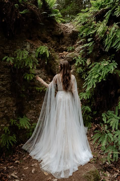 Inspired by ethereal forests of the Pacific Northwest where the trees are draped in mosses. Ivy gown is the ultimate blend of luxury and understated drama. Intriguing and totally unique, Ivy’s vine-like beading travels on your body like branches of a tree. Hand placed beaded appliques float on an illusion mesh bodice, draped with tulle, Ivy is an intricate masterpiece. A fitted beaded skirt is delicately layered with flowy tulle to let in a hint of sparkle throughout the dress, creating a multi Enchanted Forest Wedding Gown, Lord Of The Ring Wedding Dress, Wedding Dress Mystical, Wedding Dress Forest Nature, Wedding Dress Whimsical Romantic, Moss Green Wedding Dress, Forest Inspired Wedding Dress, Fall Forest Wedding Aesthetic, Wedding Dresses Nature Inspired