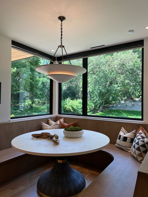 This ultra sleek breakfast nook featured in one of the 2024 Artisan Homes is unlike anything we've seen before!! The curved bench design is perfectly nestled around a beautiful round table tucked in the corner by the oversized windows, allowing in tons of natural light!   New Construction | Home Trends 2024 | Home Design | Minnesota Home Trends Curved Breakfast Nook Bench, Curved Dining Banquette, Breakfast Nook Sliding Glass Door, Curved Dining Bench With Back, Breakfast Nook Circular, Curved Bench, Oversized Windows, Minnesota Home, Bench Designs