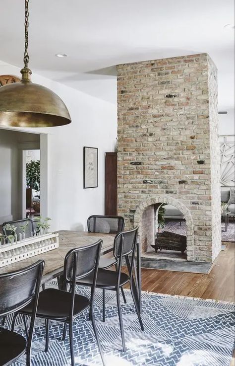 a double sided arched brick fireplace gives a cozy feel to both the dining room and the living room Double Sided Fireplace Wall, Center Of Room Fireplace, Brick Fireplace In Kitchen, Fireplace Open On Both Sides, 4 Sided Fireplace, Fireplace In Center Of Room, Fireplace Center Of Room, Fireplace Middle Of Room, Double Sided Brick Fireplace