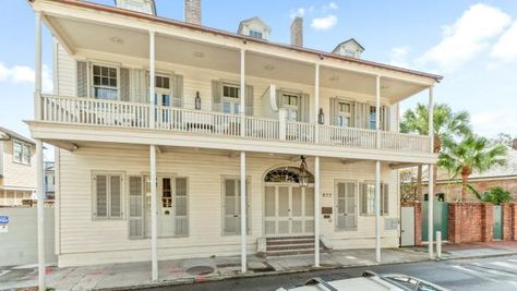 Built in the early 19th century, this three-story family home features block-wide second-floor balconies, two brick chimneys and three sweet dormers. A classic arched transom and symmetrical shutters boost its classic regional curb appeal. Colorful Contemporary Living Room, French Quarter Homes, 2nd Story Balcony, Wrought Iron Accessories, Wood Grain Tile, Second Floor Balcony, Black Feature Wall, Brick Chimney, Antique Dining Tables